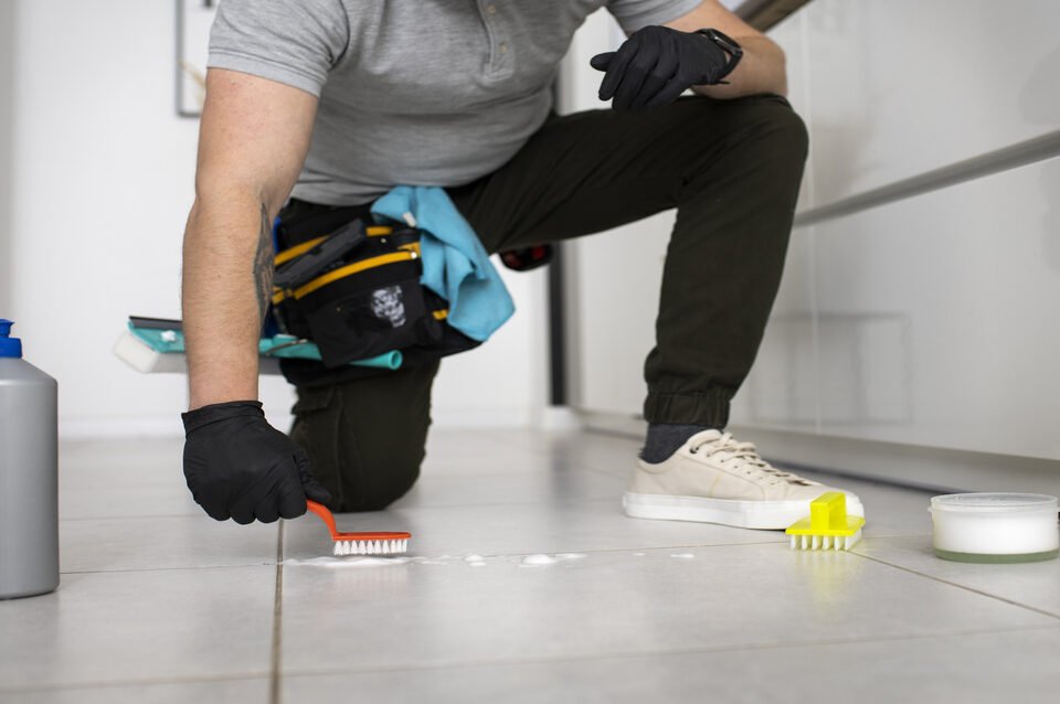 Profissional realizando a limpeza pós-obra no piso de porcelanato